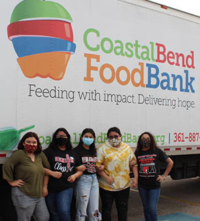 Interact club members standing in front of the food bank truck after volunteering