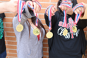 close-up-of-four-uil-participants-holding-up-their-medals